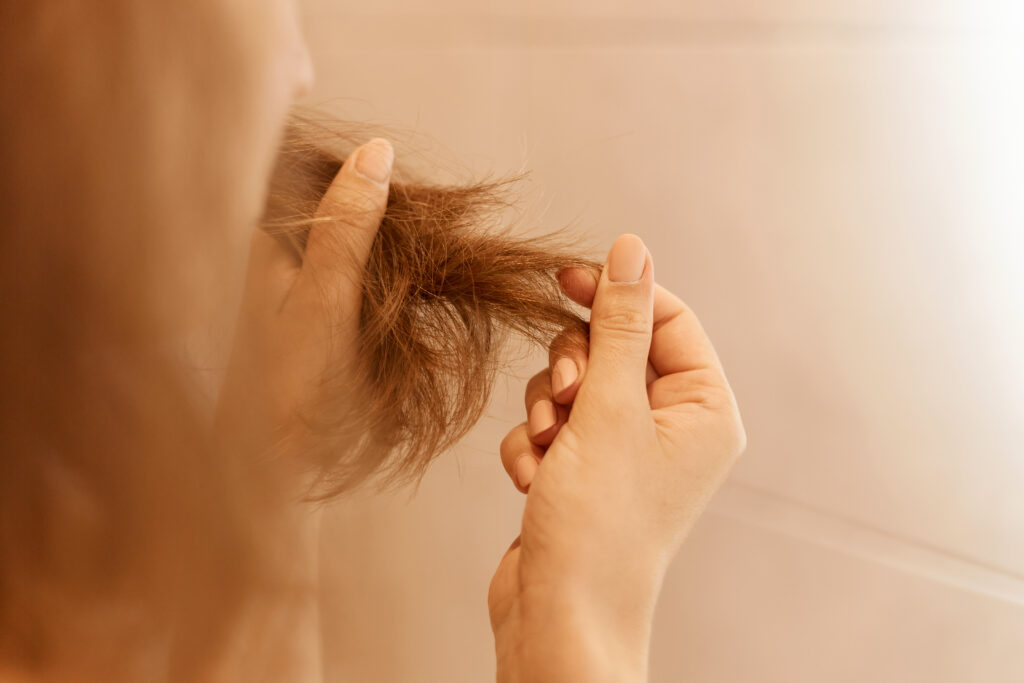 Mid-Season Skin and Hair Feeling “Off”? You’re Not Imagining It. 1 closeup portrait woman hands holding dry damaged hair eds having trichology problem
