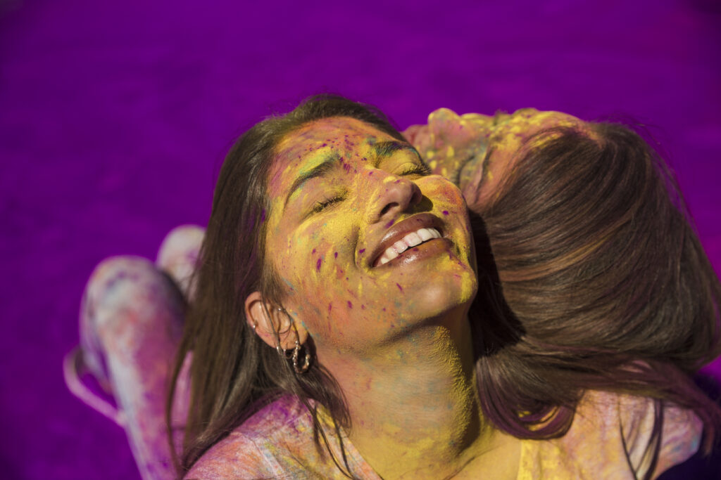 Holi Skin Guide: Before & After Care Tips to Protect Your Skin and Hair from Colors 3 smiling portrait young woman sitting back back
